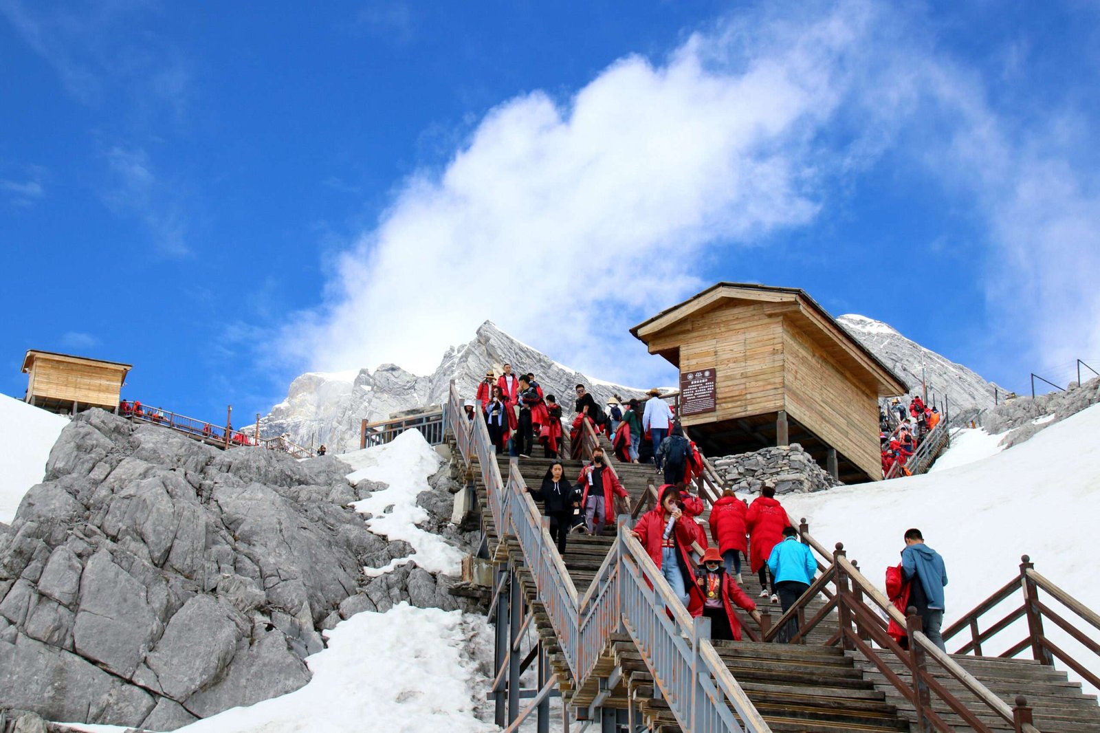 low-angle-view-people-snowcapped-mountain-against-sky